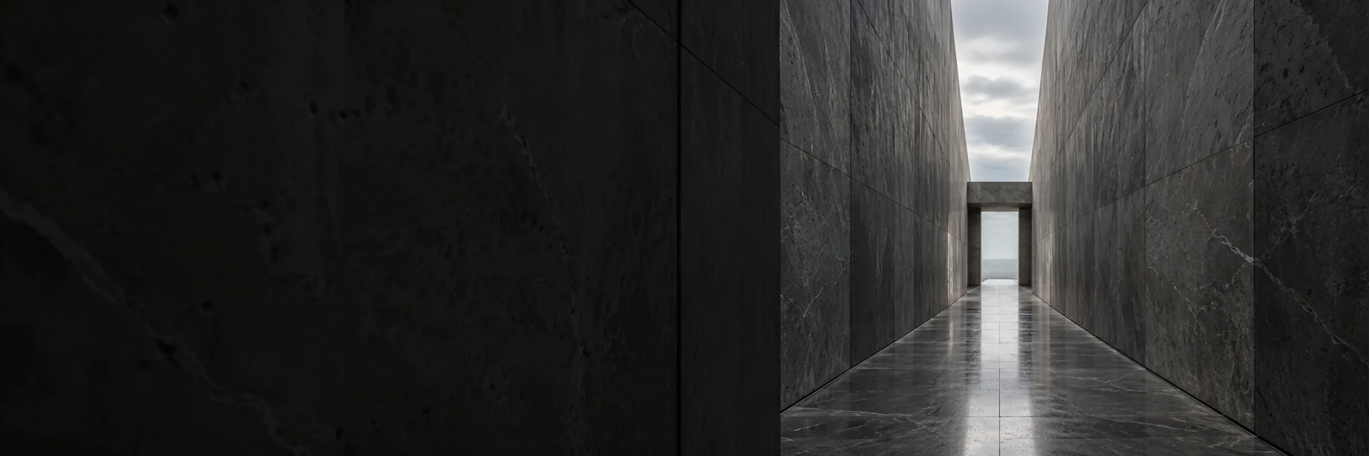 A meeting room seen through fluted glass beyond a dark stone wall.